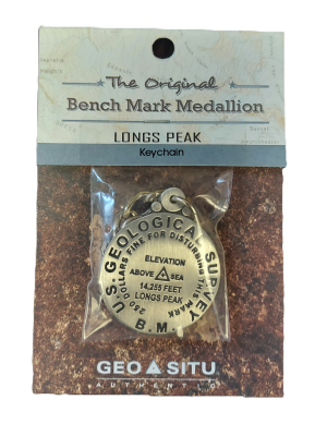 The Longs Peak Summit Marker keychain features a "Bench Mark Medallion" indicating 14,255 feet elevation by the U.S. Geological Survey, with packaging that includes a geographic map background.