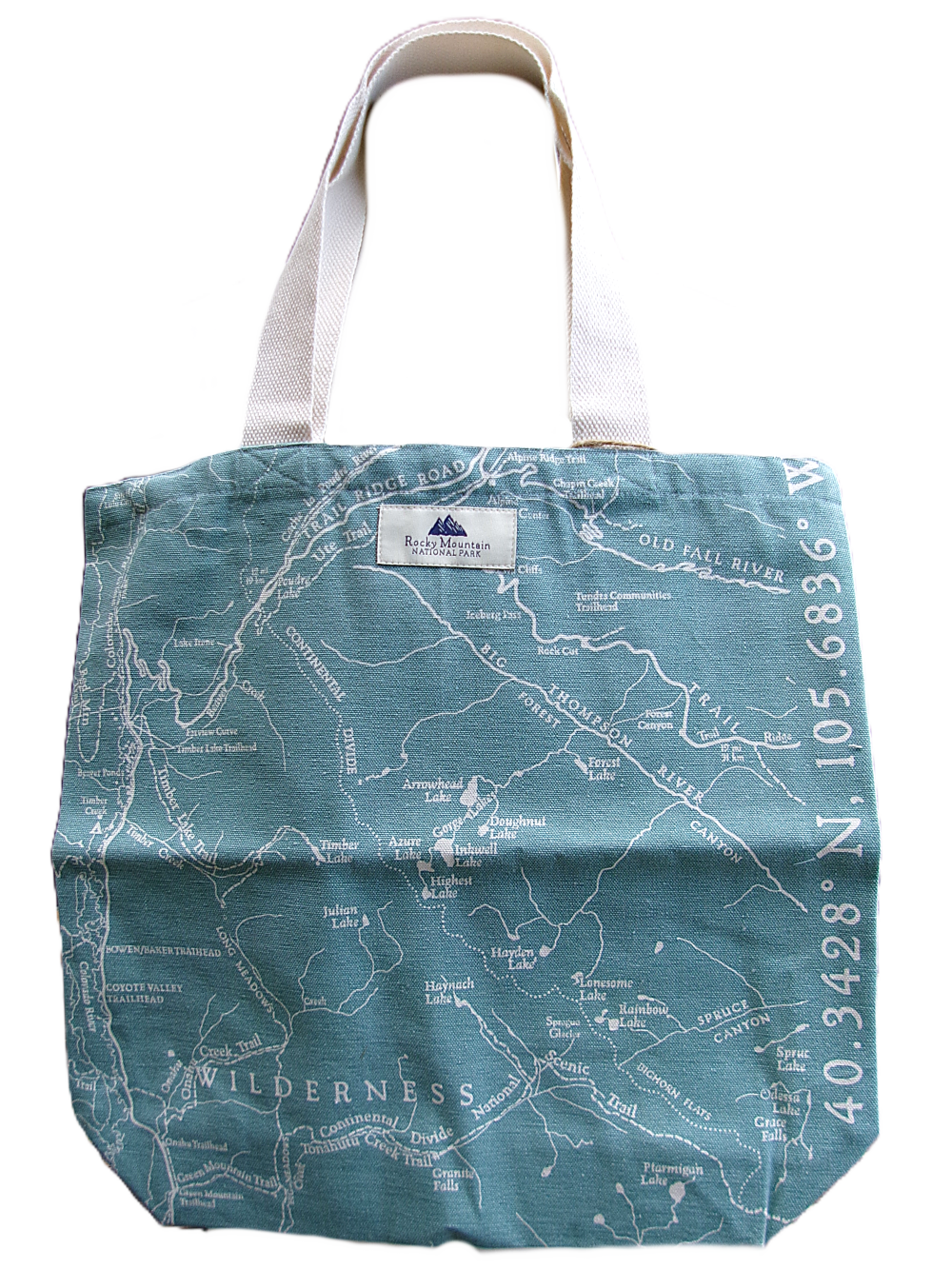 turquoise The Tote Bag - RMNP Map Turquoise features a printed wilderness map design and geographic coordinates along the right side, with sturdy white handles.