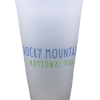 Frosted glass pint featuring the "RMNP Pint Bear Logo" with "Rocky Mountain National Park" printed in blue and green letters on the front.