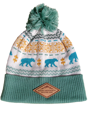 Beanie with a teal brim and pom. White background, with a blue bear, orange snowflake, and green geometric repeating design. Leather patch on brim with "Rocky Mountain National Park."