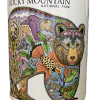 The Mug - RMNP Bear Collage is a ceramic mug displaying a vibrant bear illustration filled with detailed animals, plants, and landscapes, labeled "Rocky Mountain National Park.