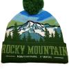 The Snowy Mountains Beanie is a green knit hat with a pom-pom, featuring a mountain and forest design plus "Rocky Mountain National Park" on the front cuff.