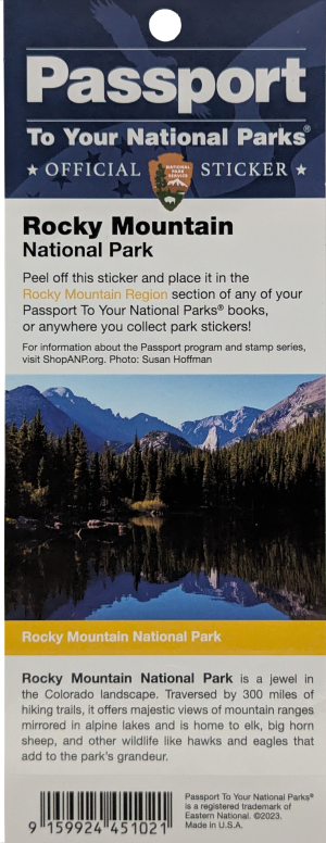 Sticker - RMNP Passport Stamp New, showcasing Rocky Mountain National Park with a lake, forest, and snow-capped mountains beneath a blue sky, along with informational text about the park and the passport sticker program.
